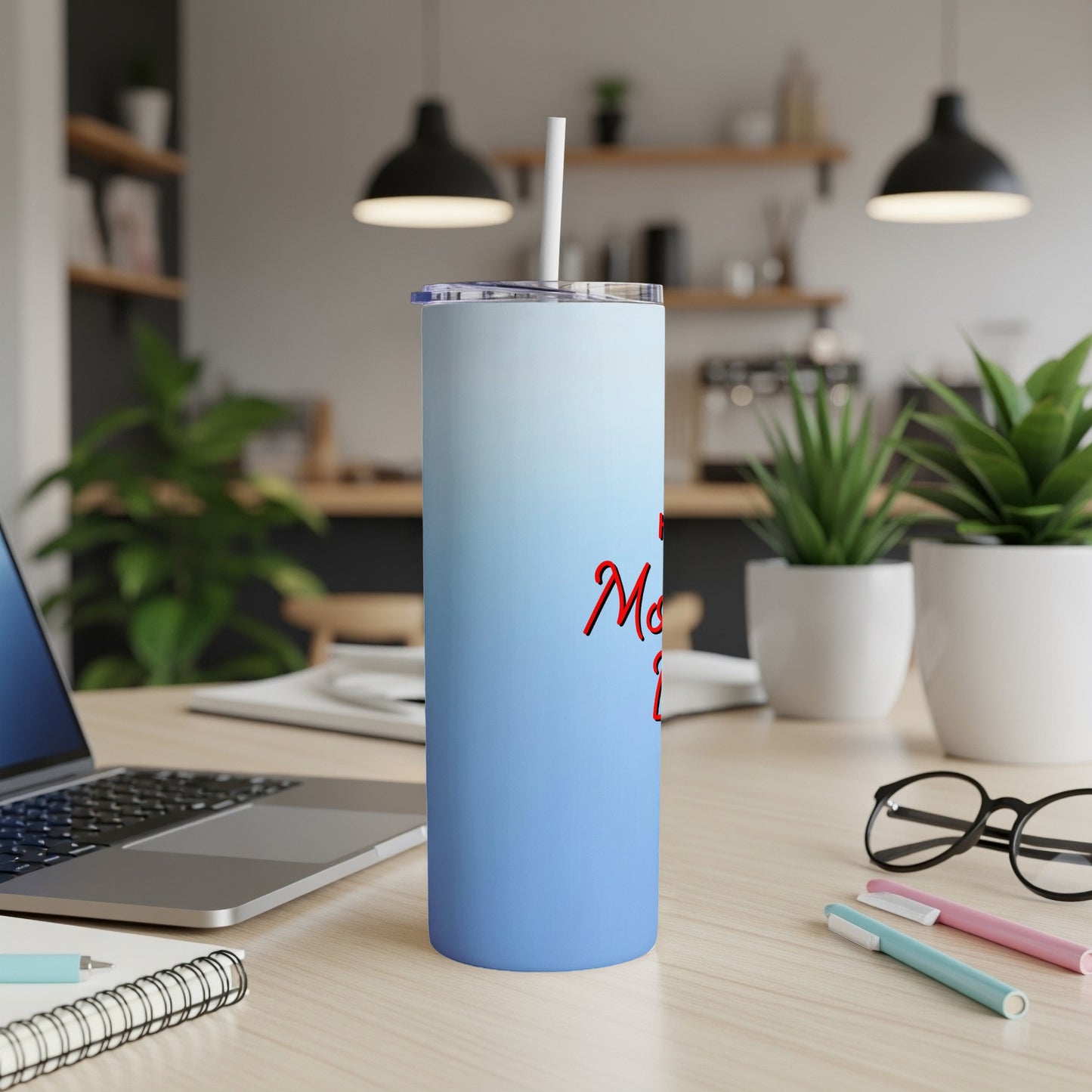 Blue gradient tumbler with red script text "Mama" on a desk.