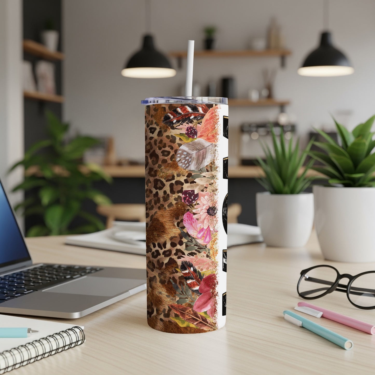Leopard print tumbler with flowers and feathers, straw inserted.