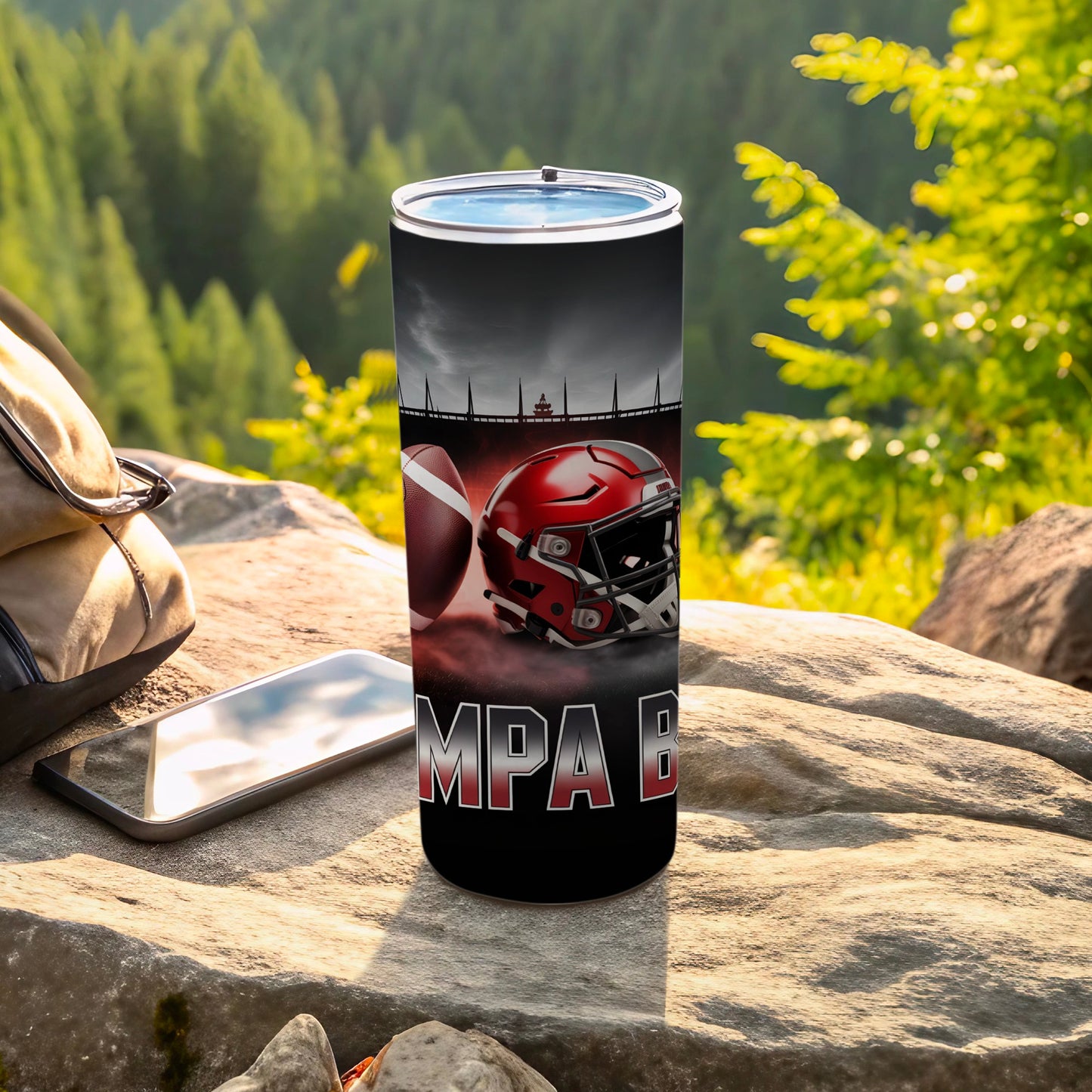 Tumbler featuring a football helmet and "Tampa Bay" text on a rocky outdoor surface.