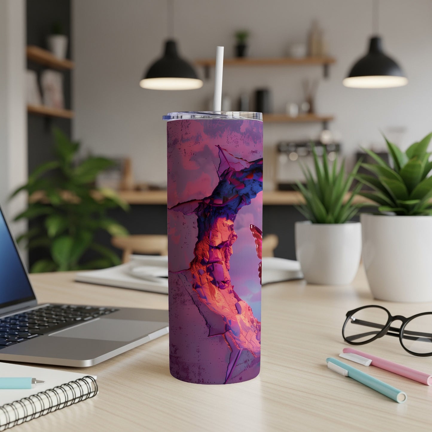 Purple tumbler with abstract, cracked rock design on a desk.