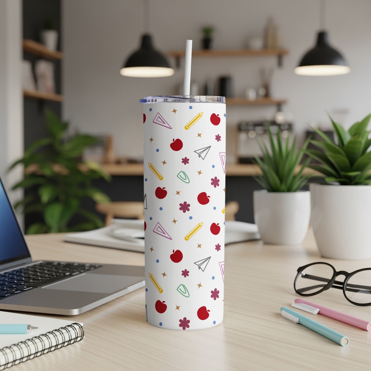White tumbler with colorful school supply pattern and straw.