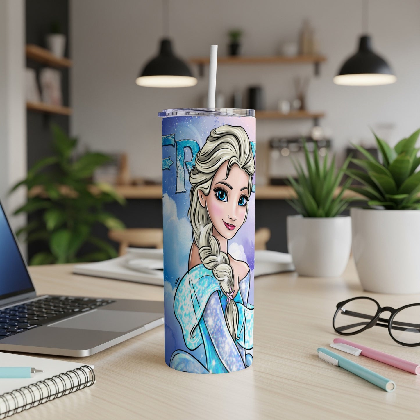 Frozen Elsa character on a blue ombre tumbler with white straw on a desk.