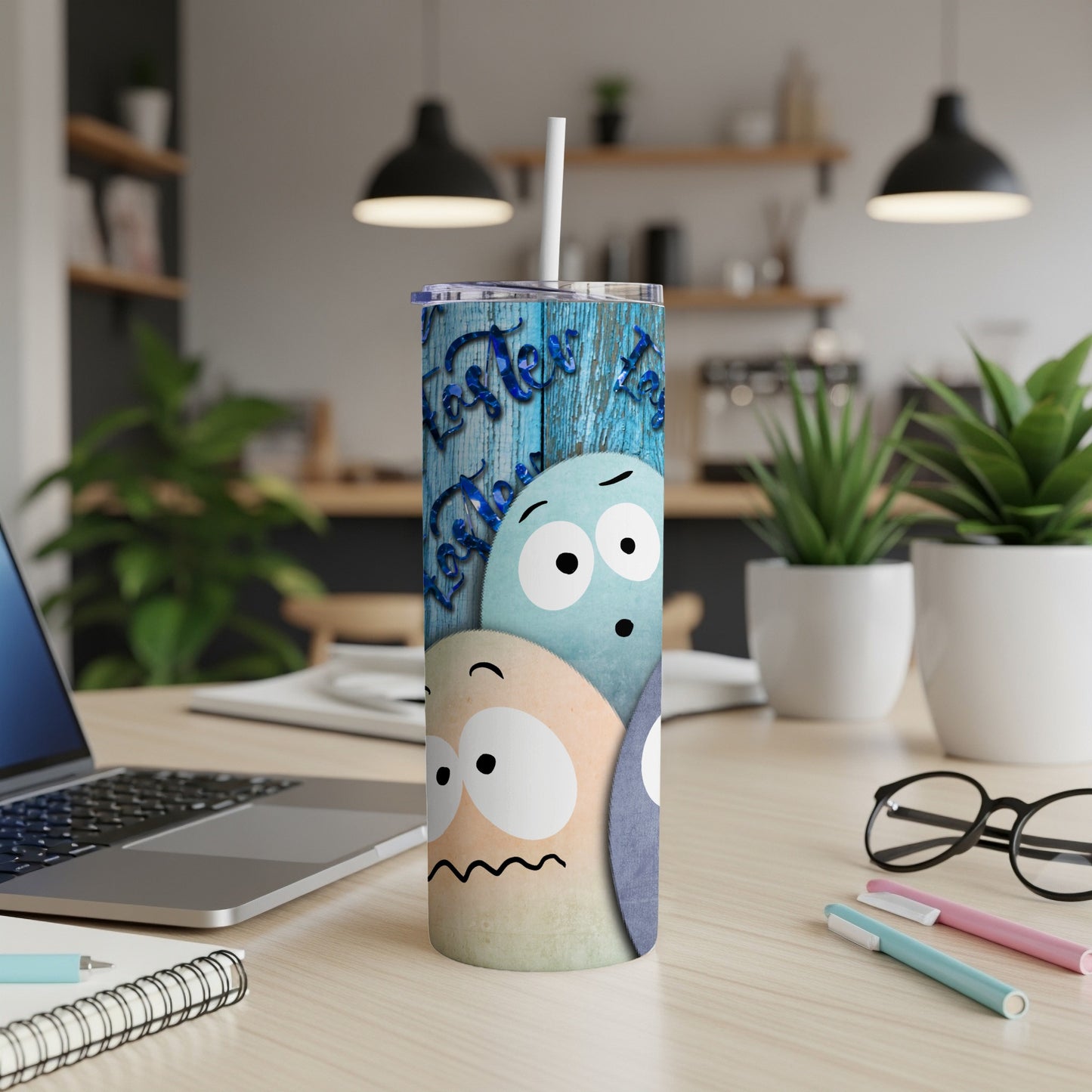 Easter-themed tumbler with cartoon egg characters and blue wood background.