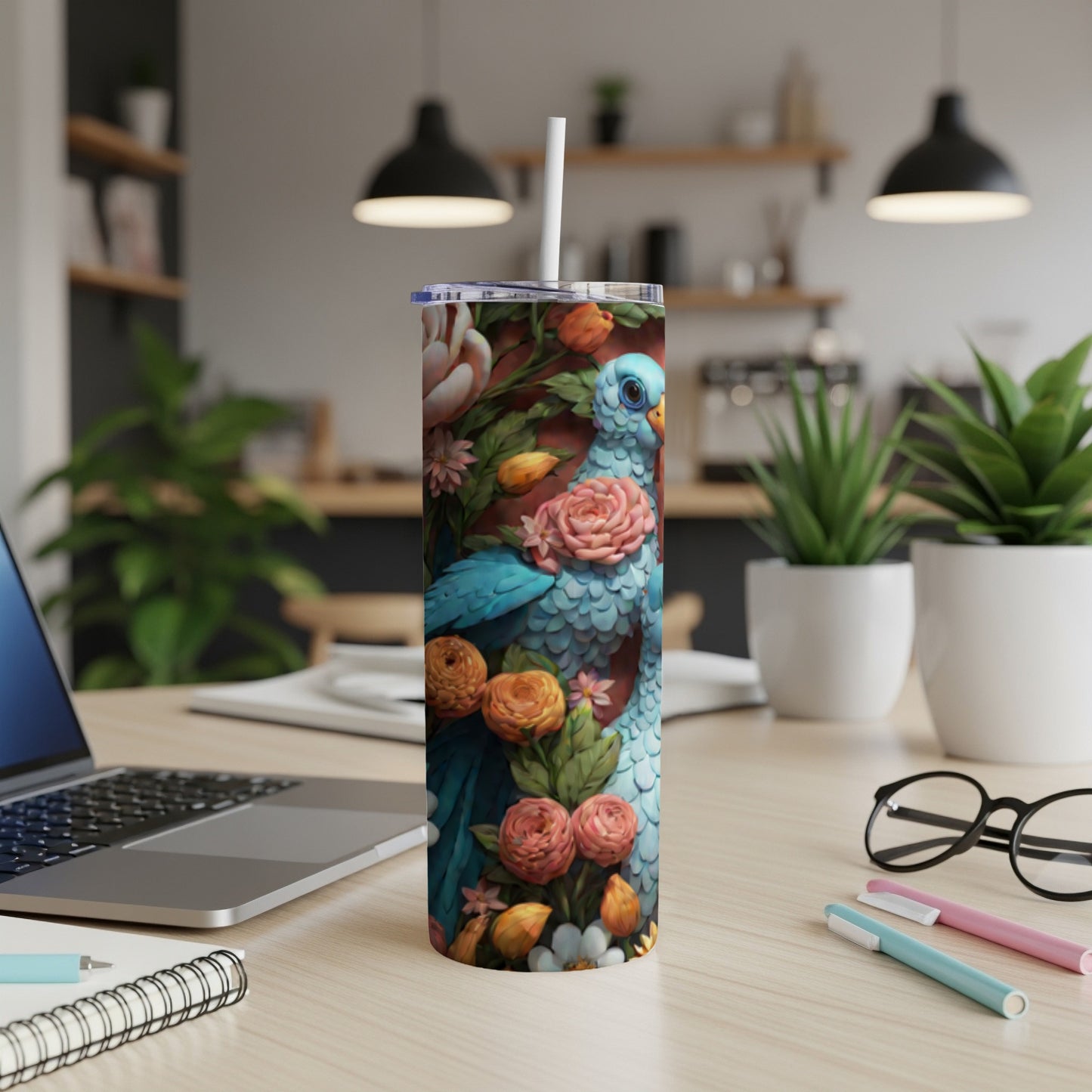 Blue bird and floral pattern on a white tumbler with a straw.