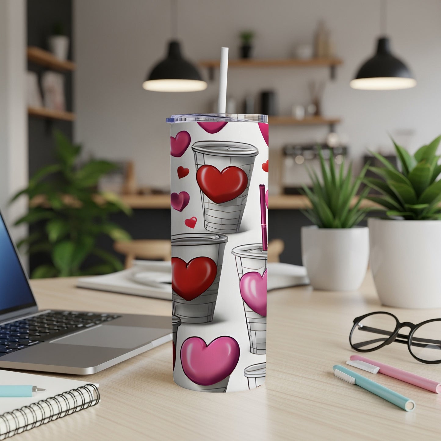 White tumbler with scattered red and pink hearts and a straw.