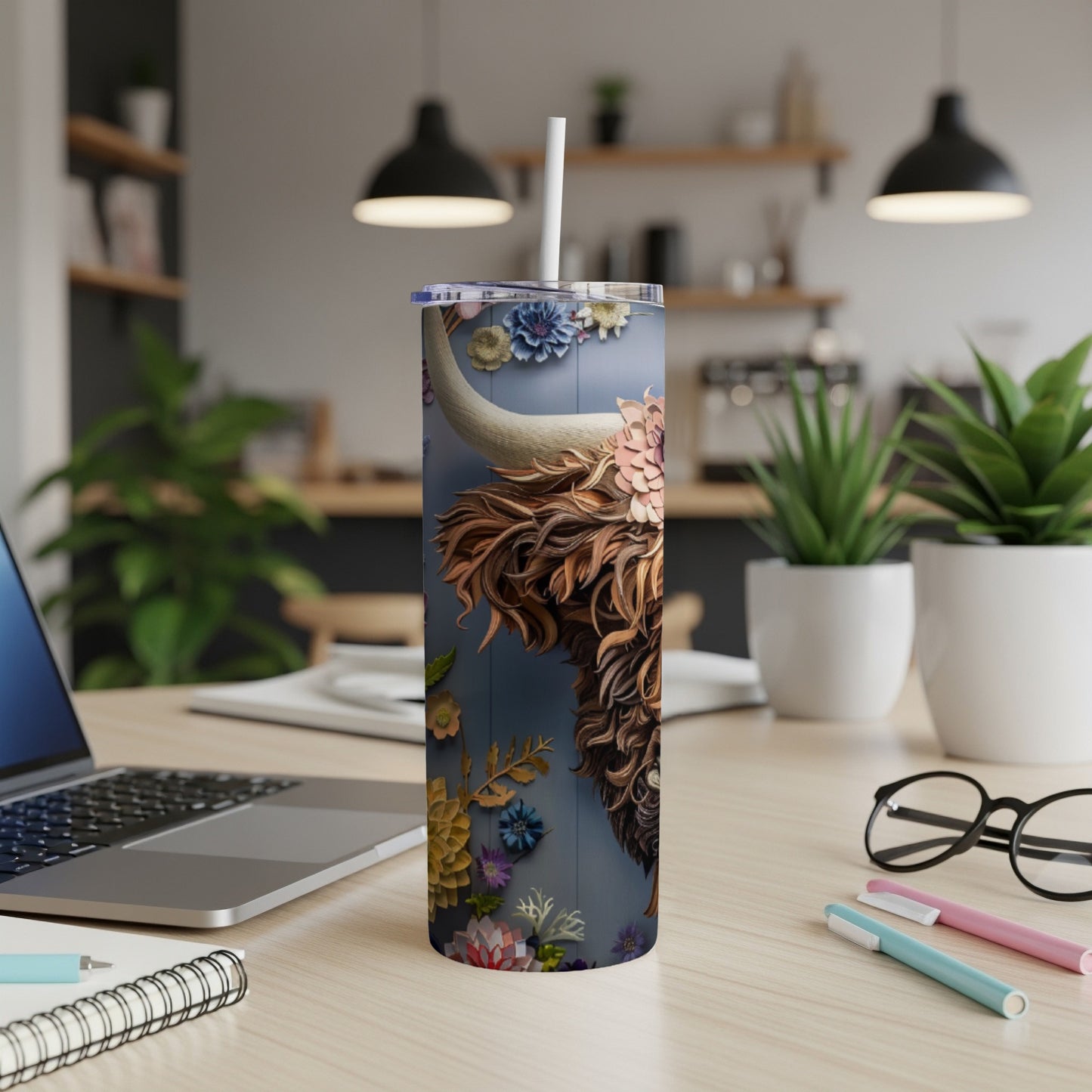 Tumbler featuring a detailed, floral-covered Highland cow portrait on a dark blue background.