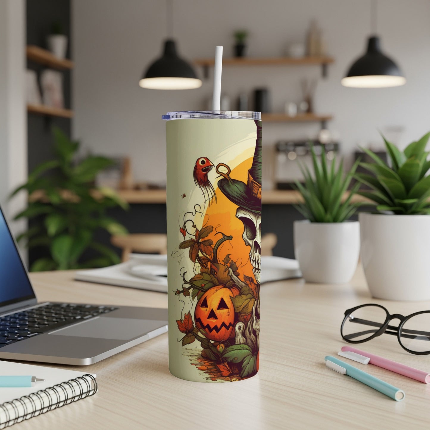 Halloween tumbler with skull, pumpkin, and spooky characters on a desk.