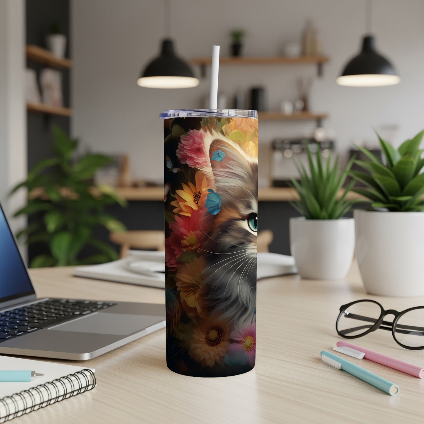 Tumbler with a fluffy cat face surrounded by colorful flowers and butterflies.