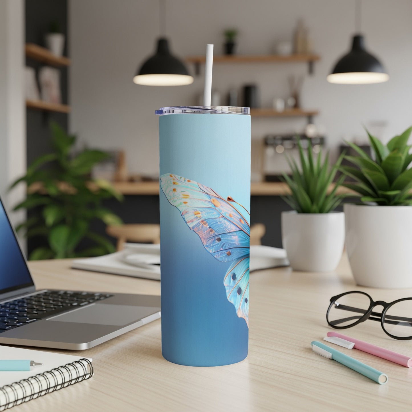 Blue gradient tumbler with a butterfly wing design and a straw.