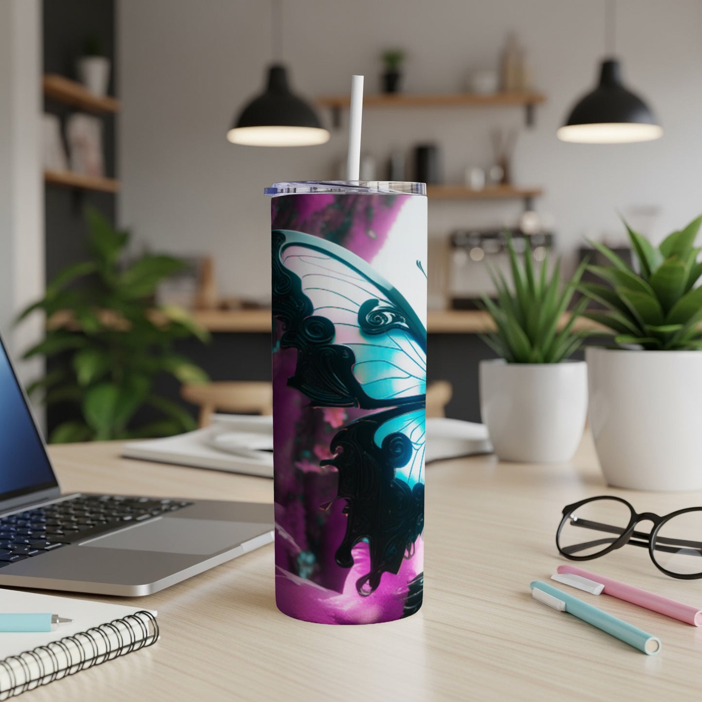 Tumbler with vibrant butterfly design and straw on a desk.