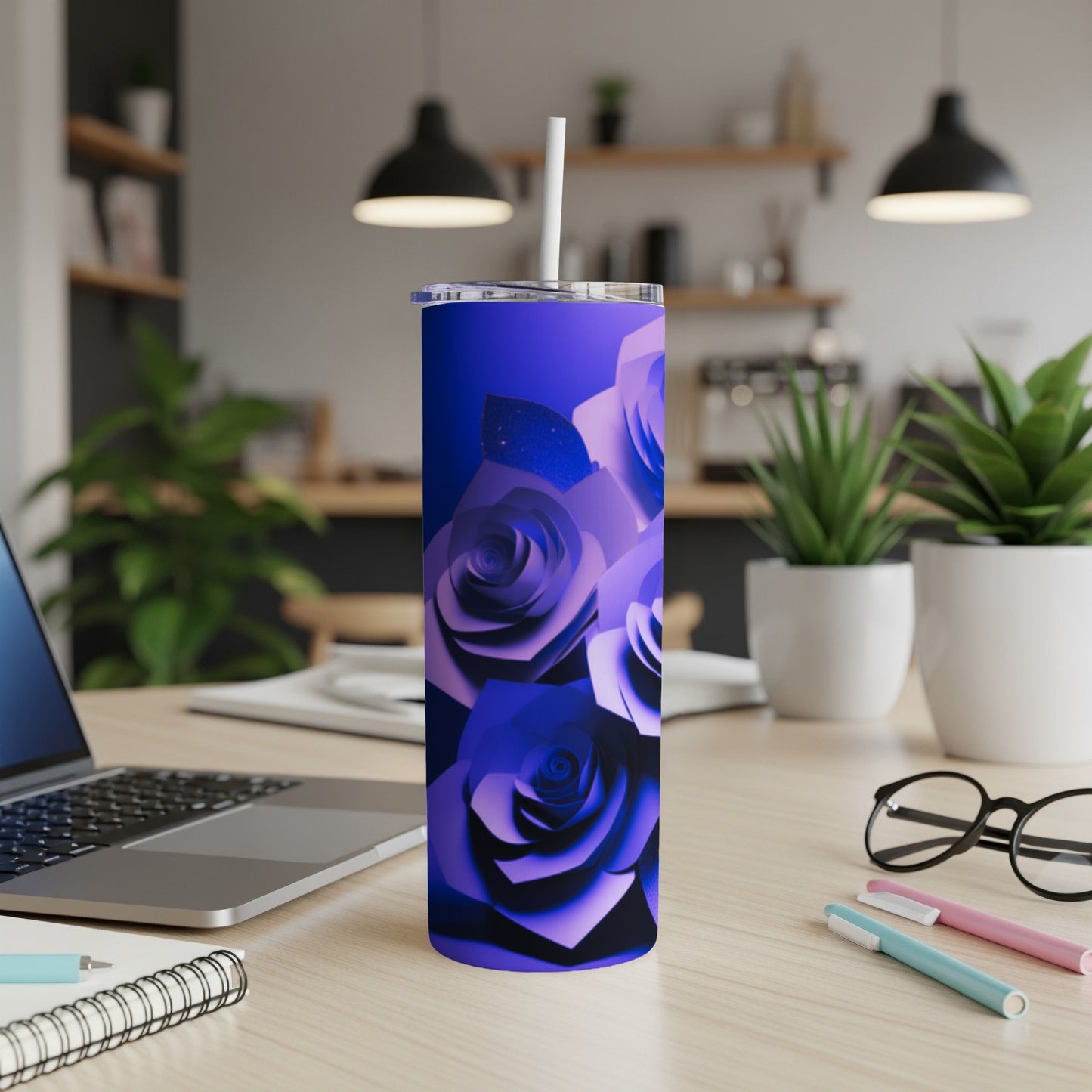 Blue rose patterned tumbler with white straw on a desk.