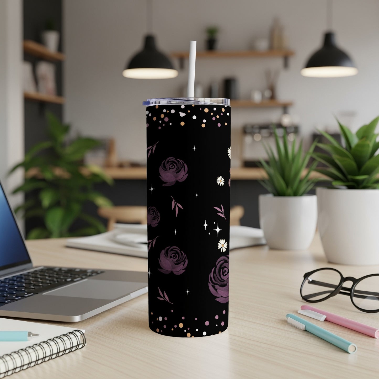 Black tumbler with purple floral and star pattern, white straw.