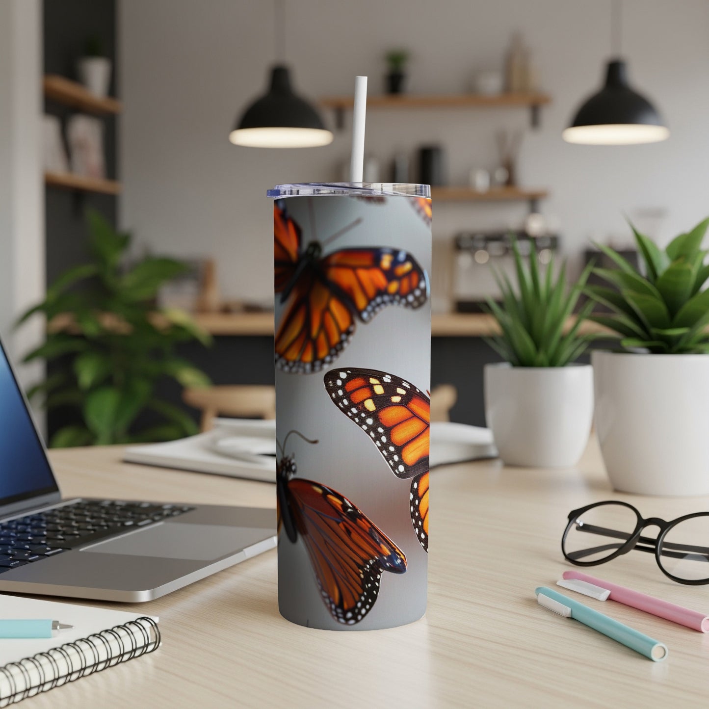 Monarch butterflies on a gray tumbler with a white straw.