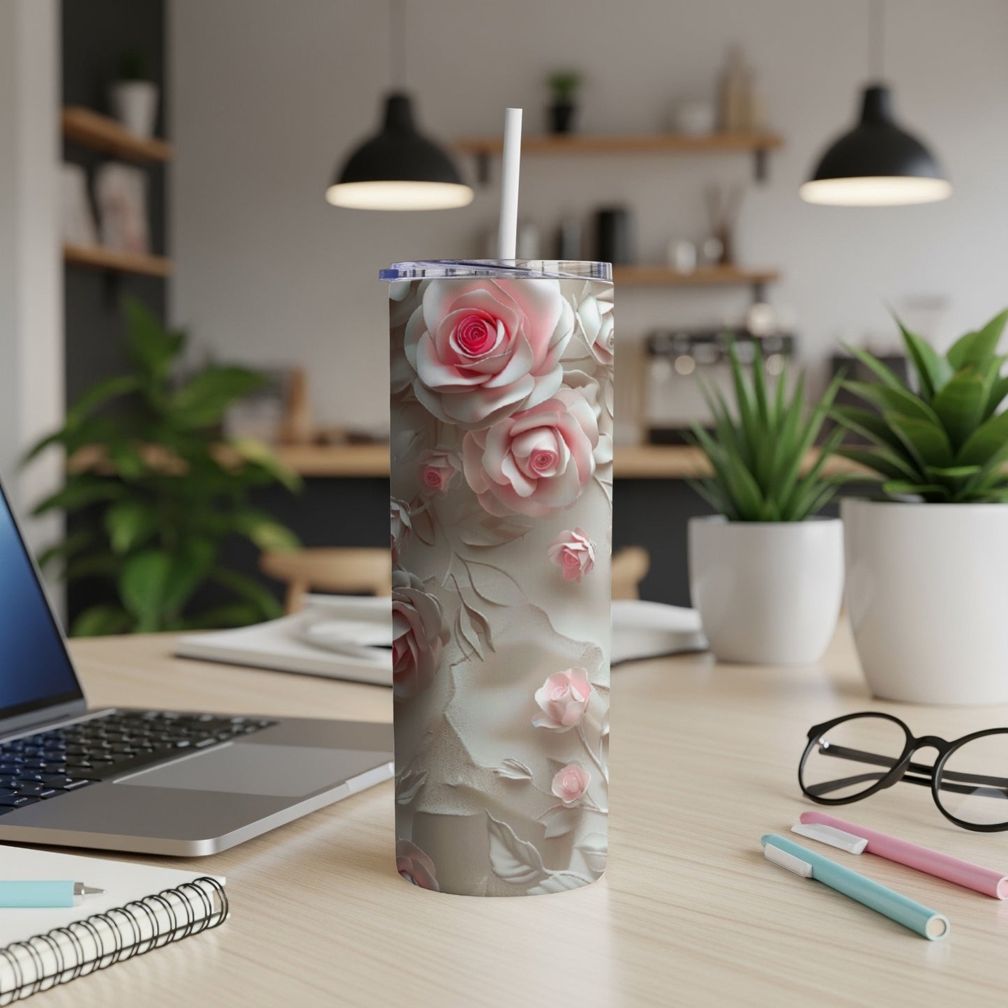 Floral pink rose textured tumbler with straw on a desk.