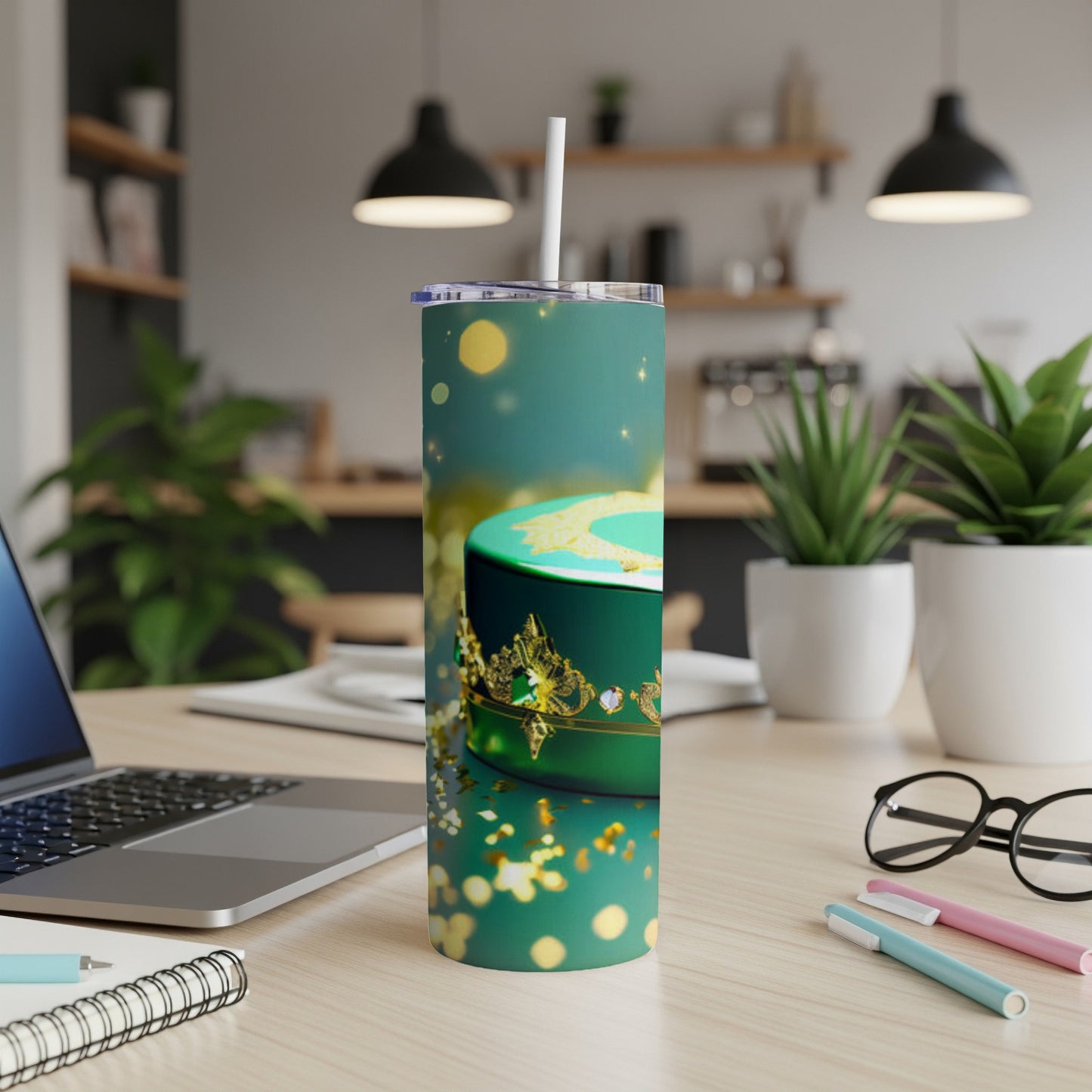 Teal tumbler with gold crown and confetti design, with a straw.
