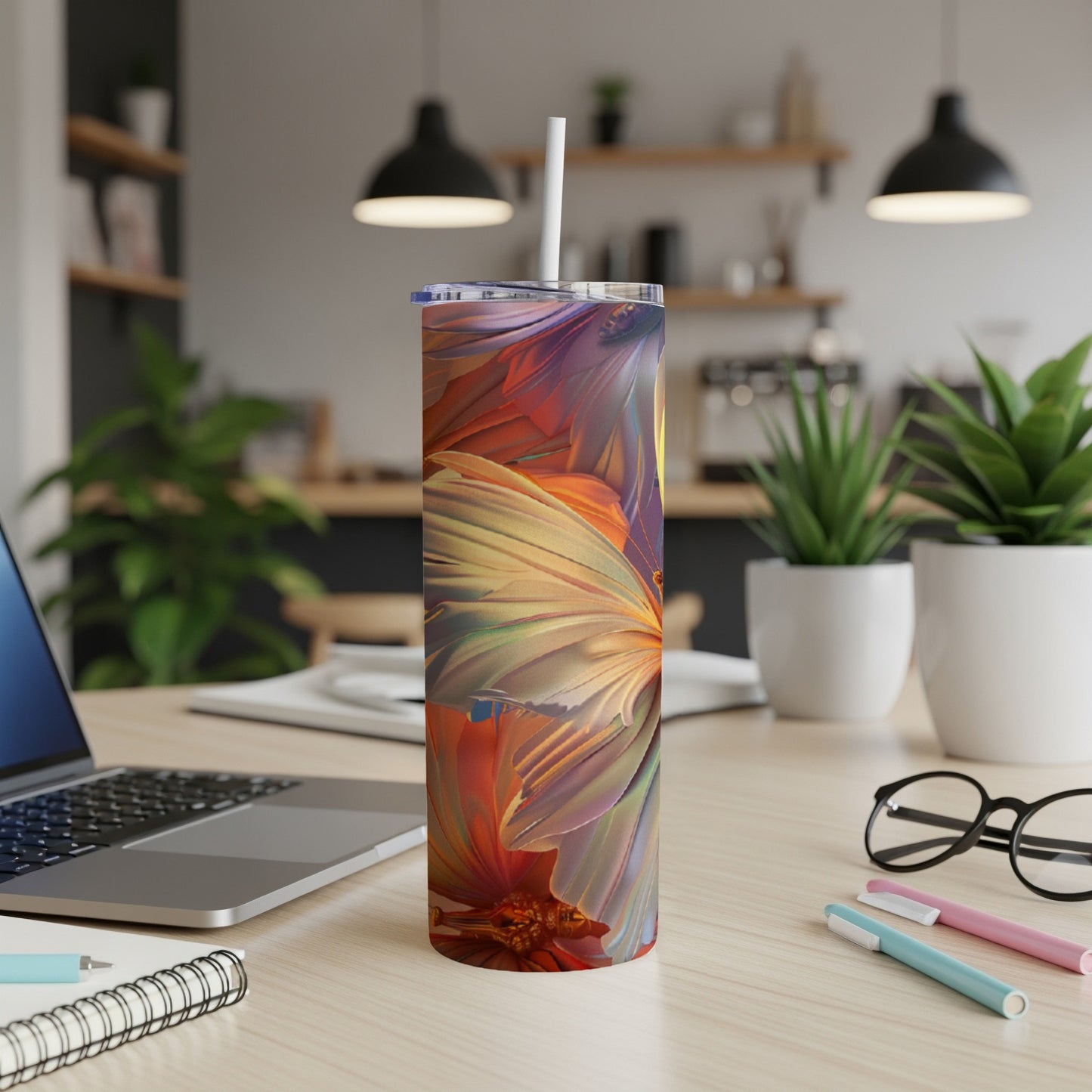 Tall tumbler with vibrant, abstract floral design on a desk.
