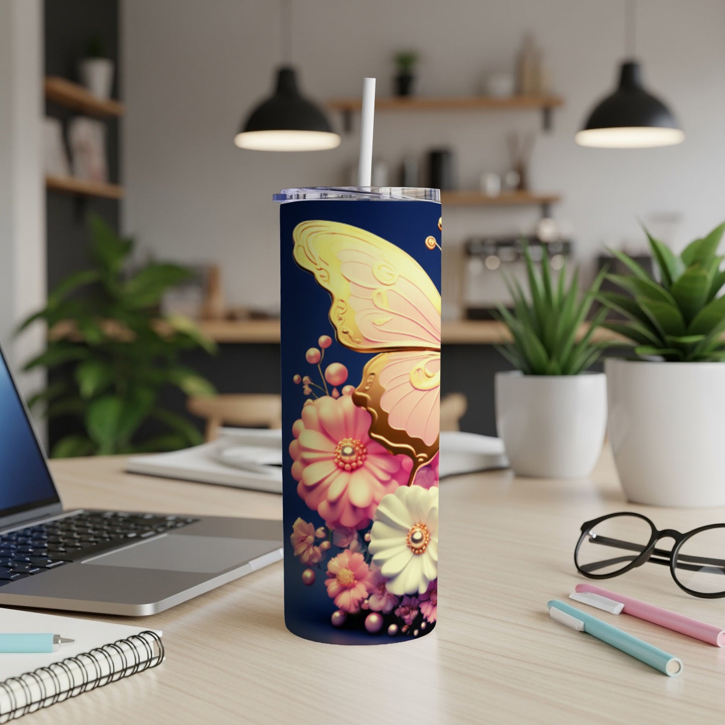 Butterfly and floral design on a dark navy blue tumbler with a straw.