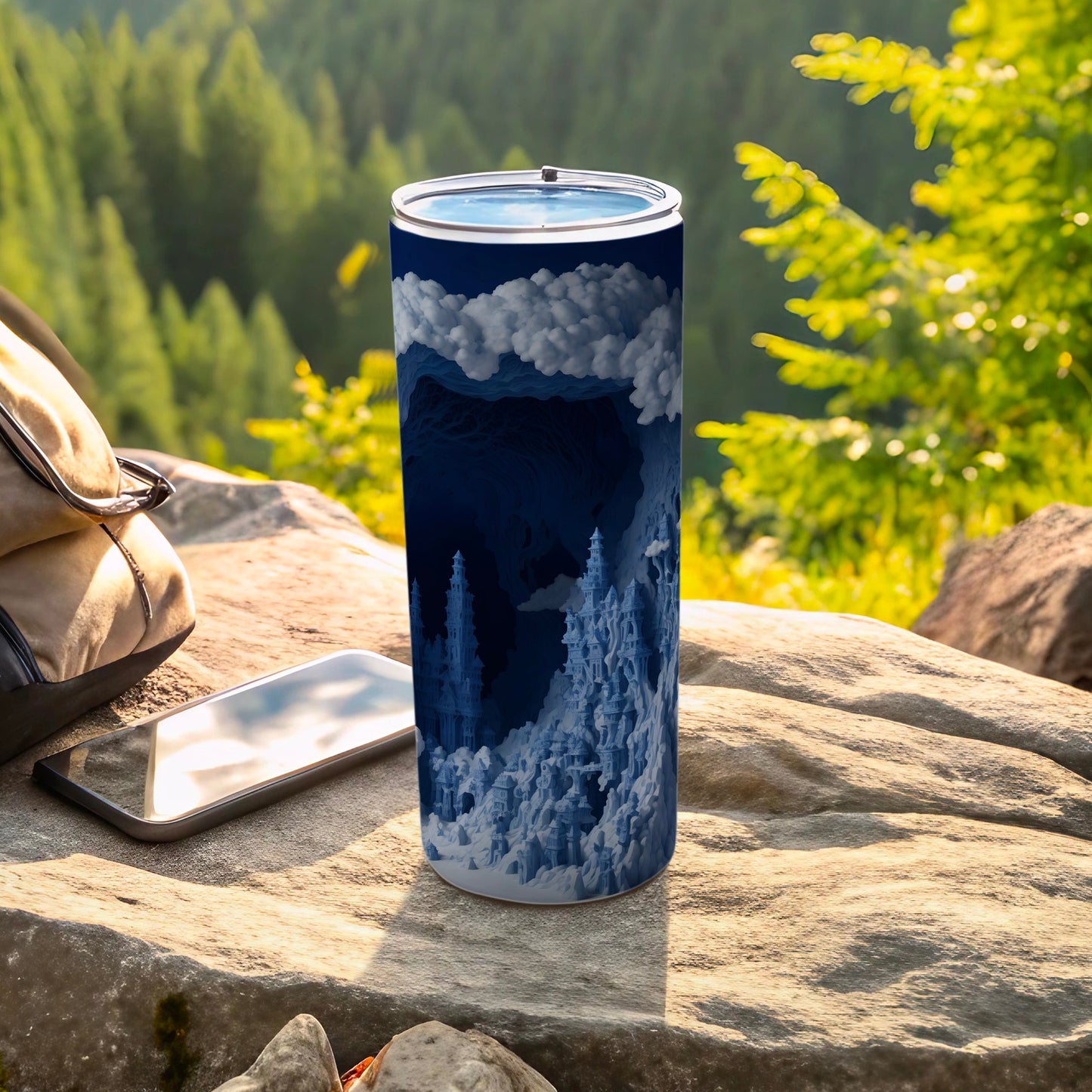 Blue abstract landscape tumbler with clouds and mountains, resting on rock.