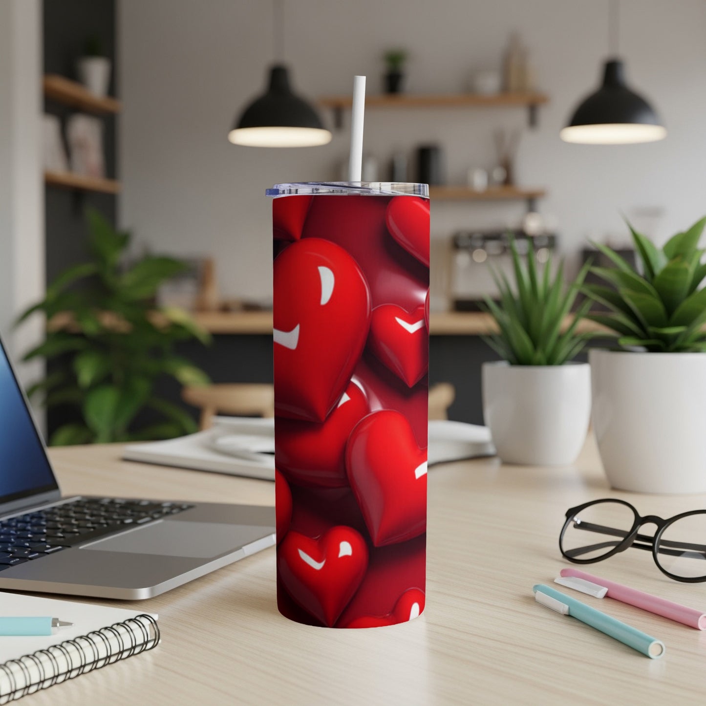 Red heart pattern on a tumbler with a straw, on a desk.