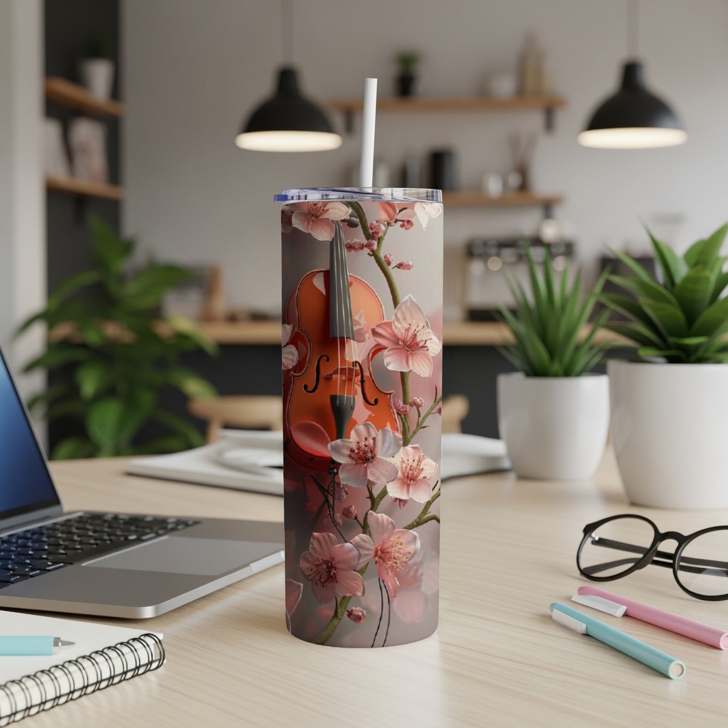 Violin and cherry blossoms on a slim tumbler with laptop and pens.