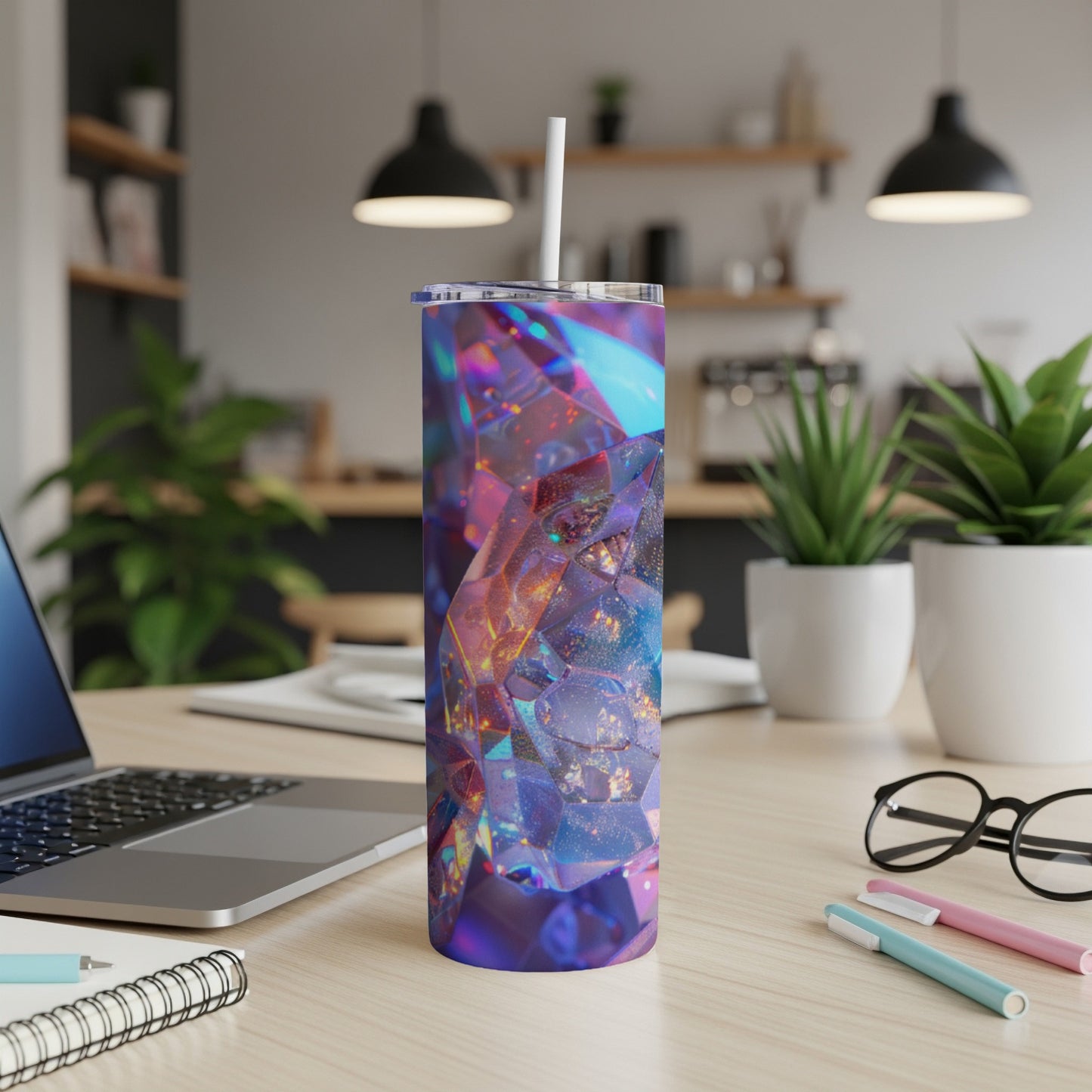 Tumbler with faceted, iridescent geometric design on a desk.