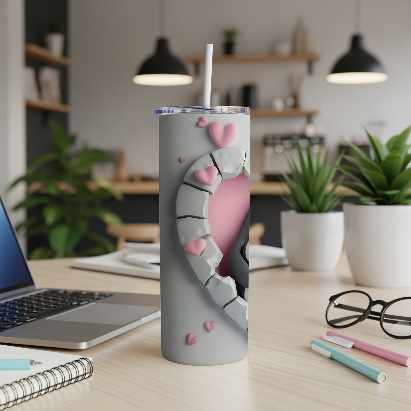 Gray tumbler with a broken heart design and pink hearts.