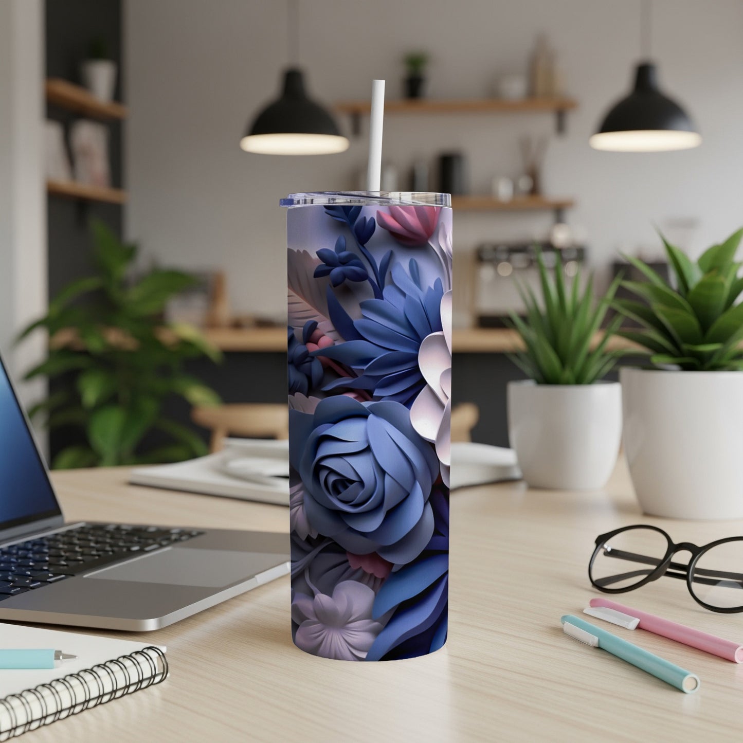 Blue floral tumbler with a white straw on a desk.