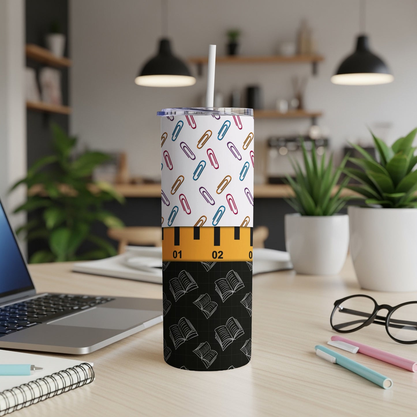White tumbler with colorful paperclips and book pattern, white straw.