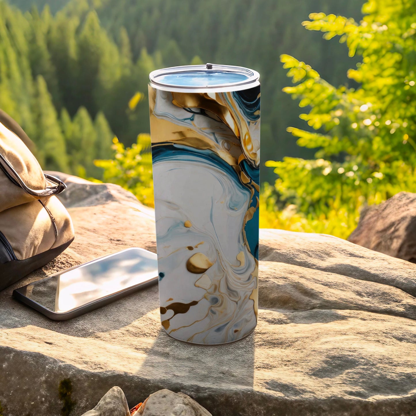 Tumbler with abstract blue and gold marbling pattern on rocky surface.