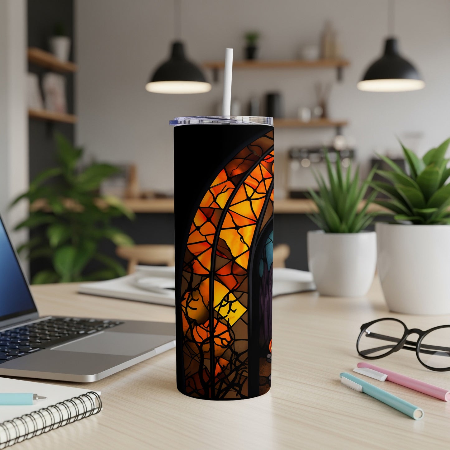 Black tumbler with stained glass design of arched window and warm light.