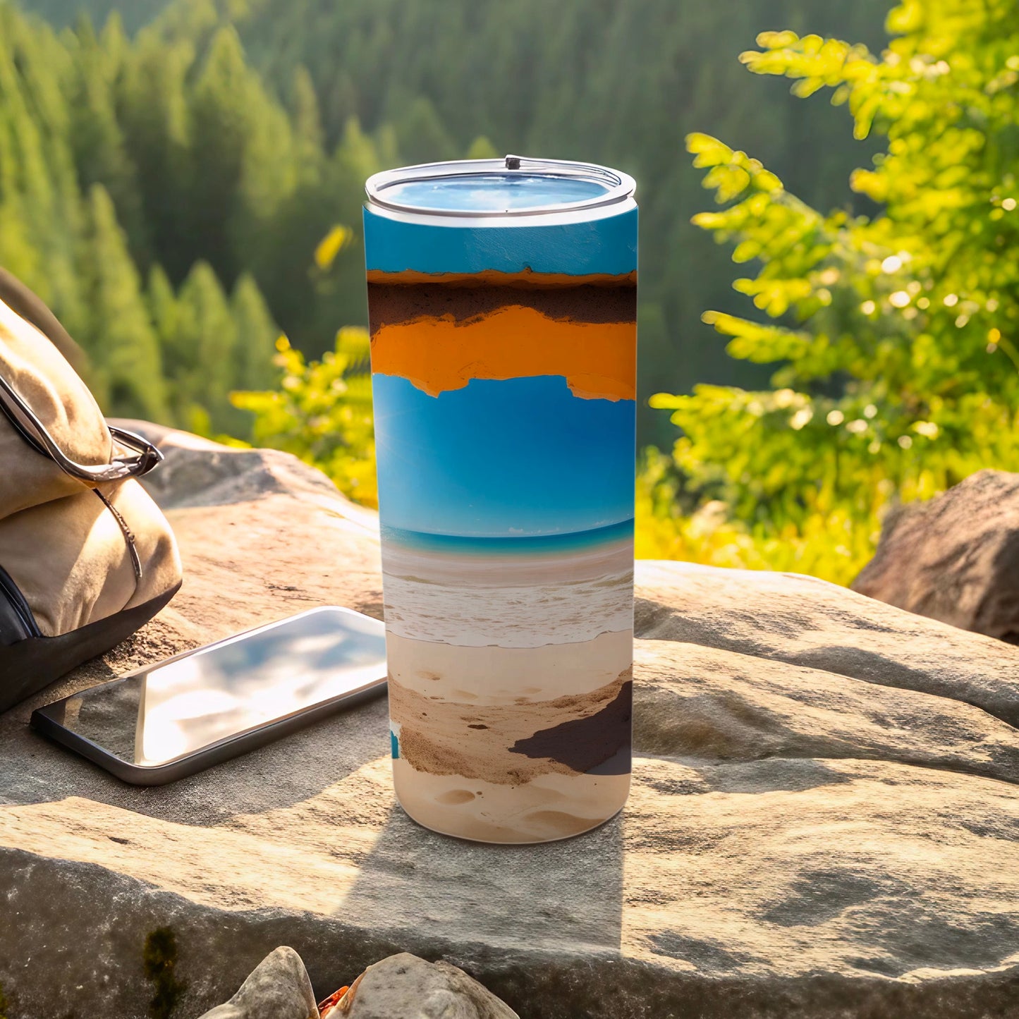 Tall tumbler with a beach landscape design, resting on rocks outdoors.