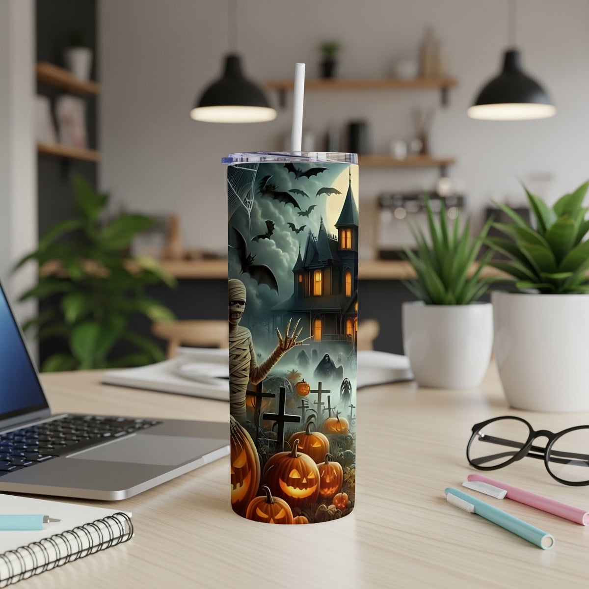 Halloween tumbler with mummy, haunted house, bats, pumpkins, and gravestones.