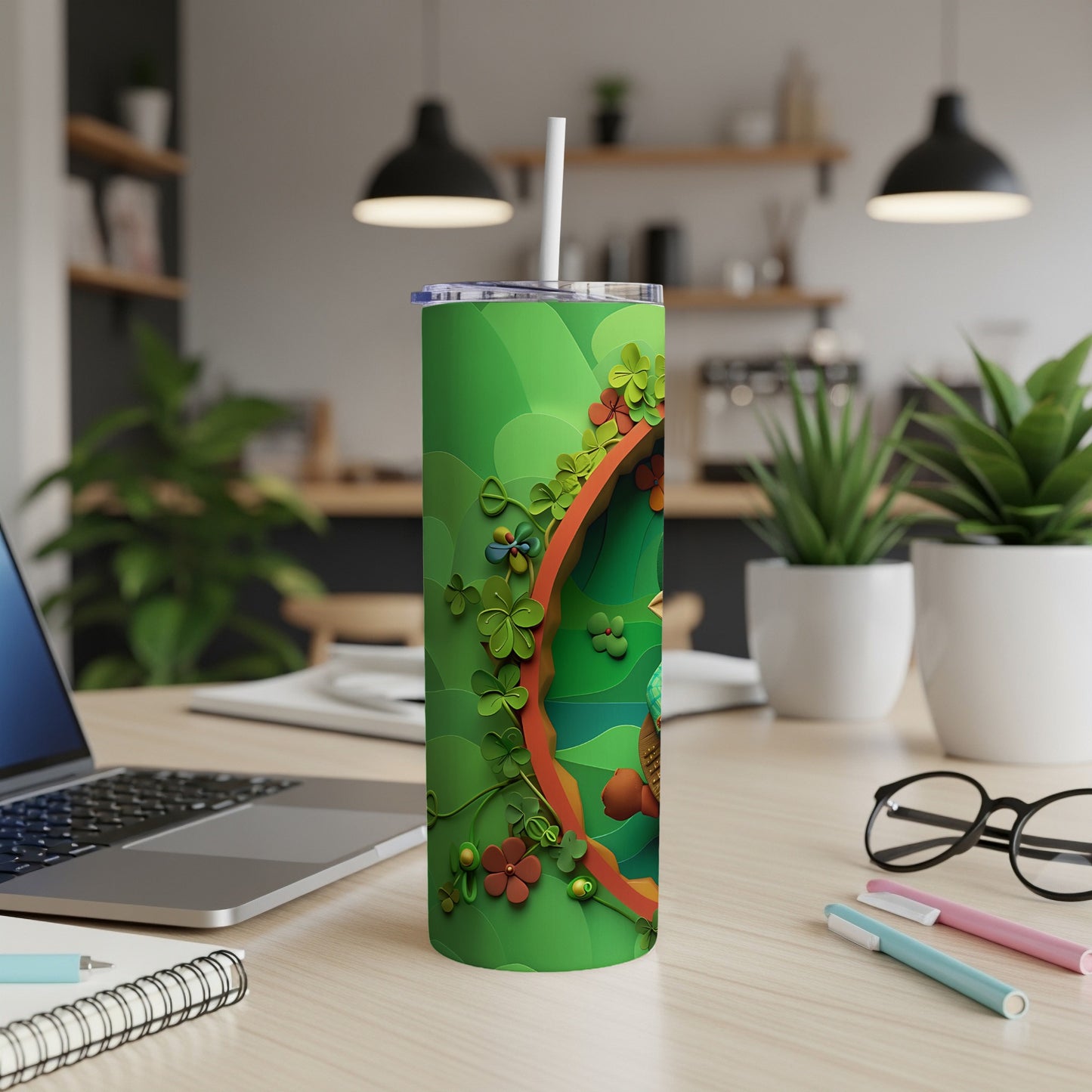 Green tumbler with shamrocks and floral accents, on a desk.