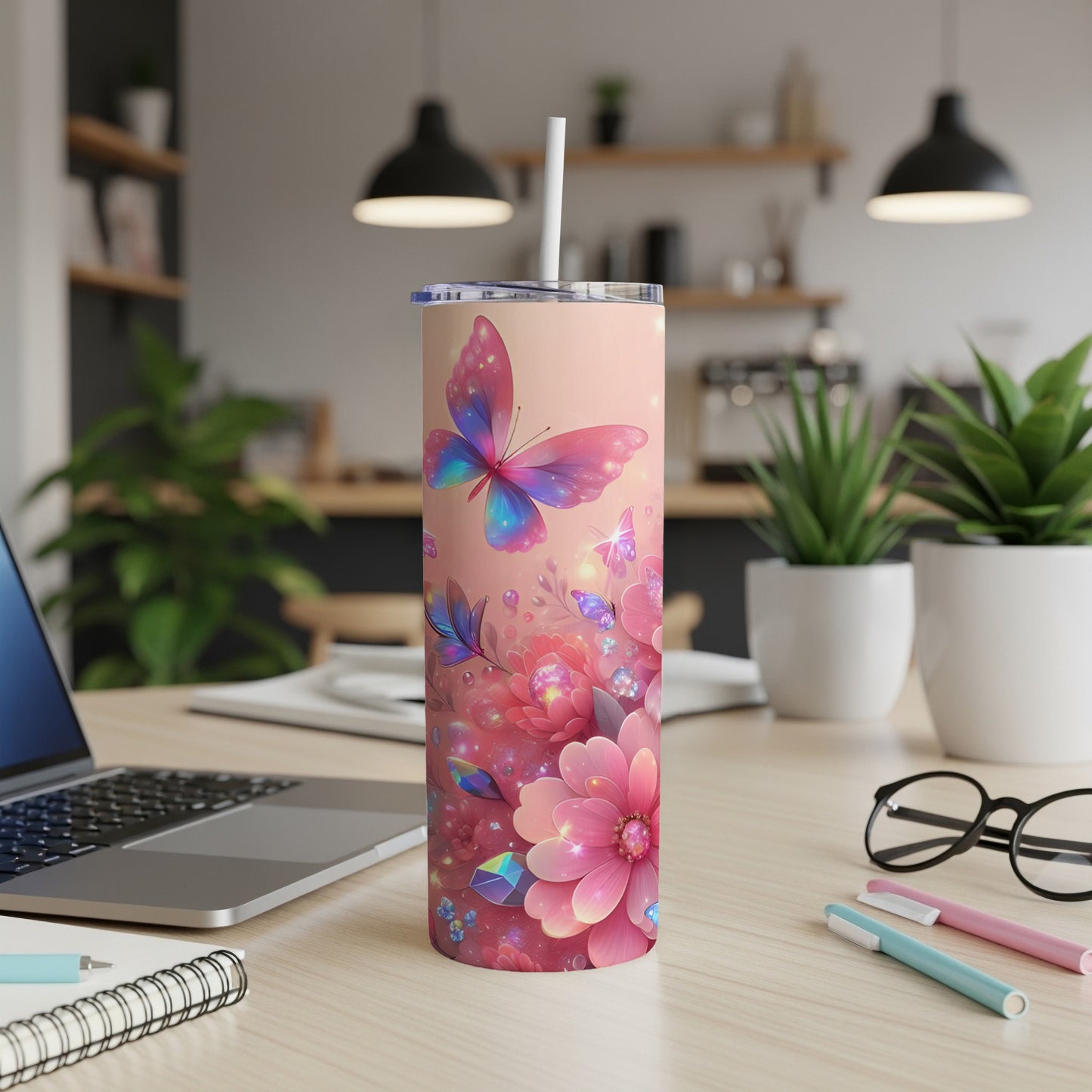 Pink tumbler with colorful butterflies and flowers, on a desk.