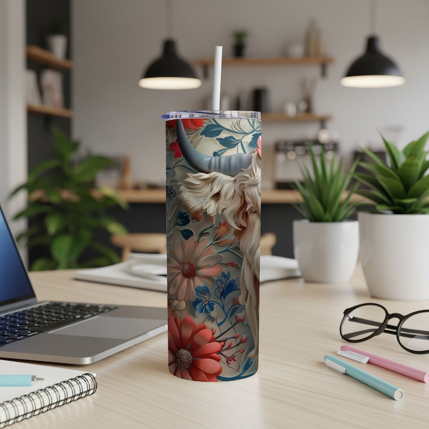 Tumbler with Highland cow and floral pattern, straw inserted.