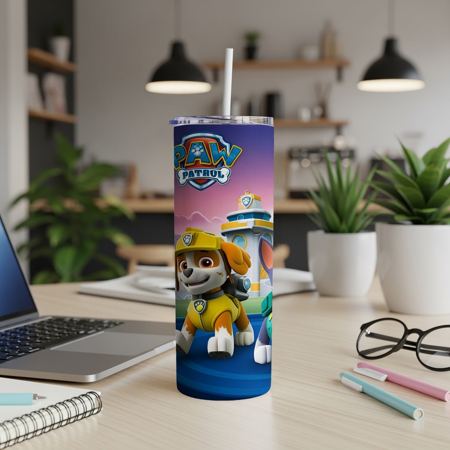 Paw Patrol tumbler with Chase character on a desk with a laptop.