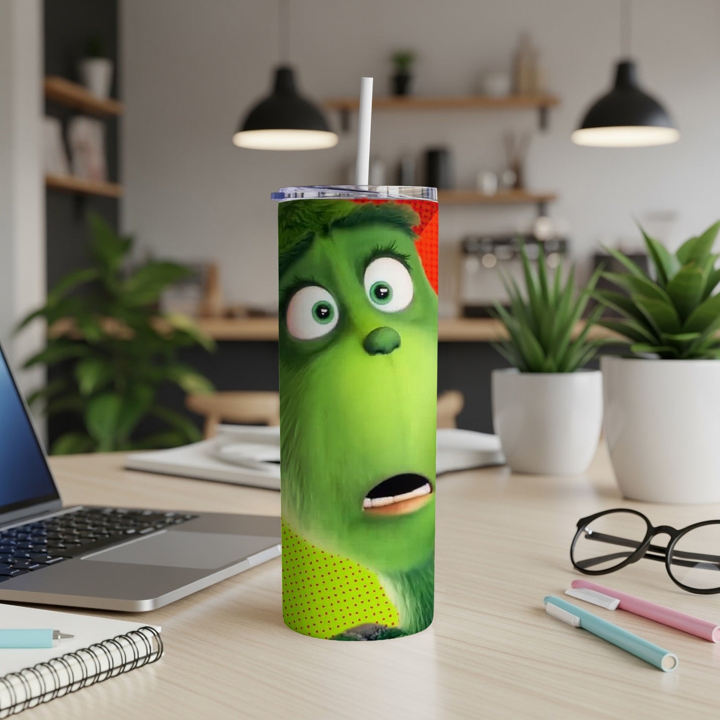 The Grinch character on a green skinny tumbler with a straw.