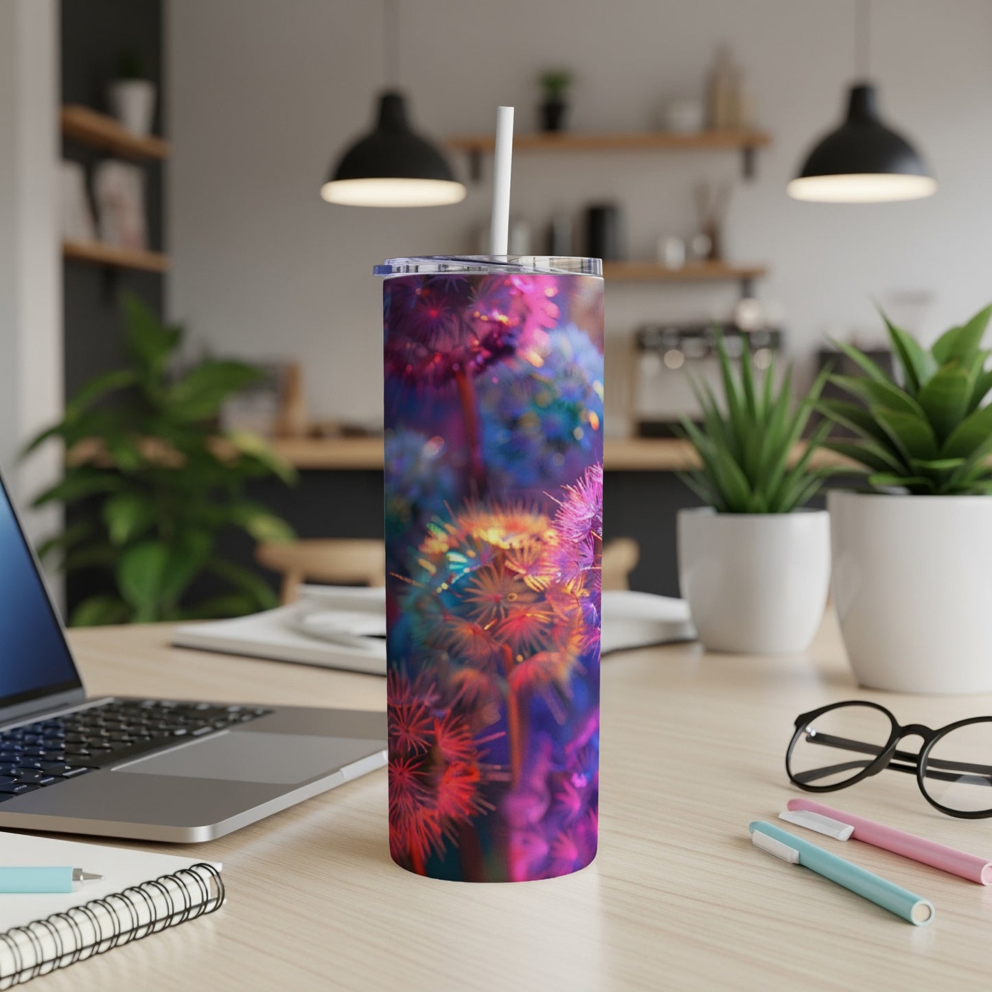 Tumbler with colorful dandelion seed head pattern on a desk.