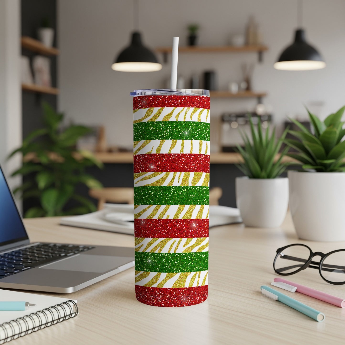 Red, green, and gold glitter striped tumbler with a white straw.