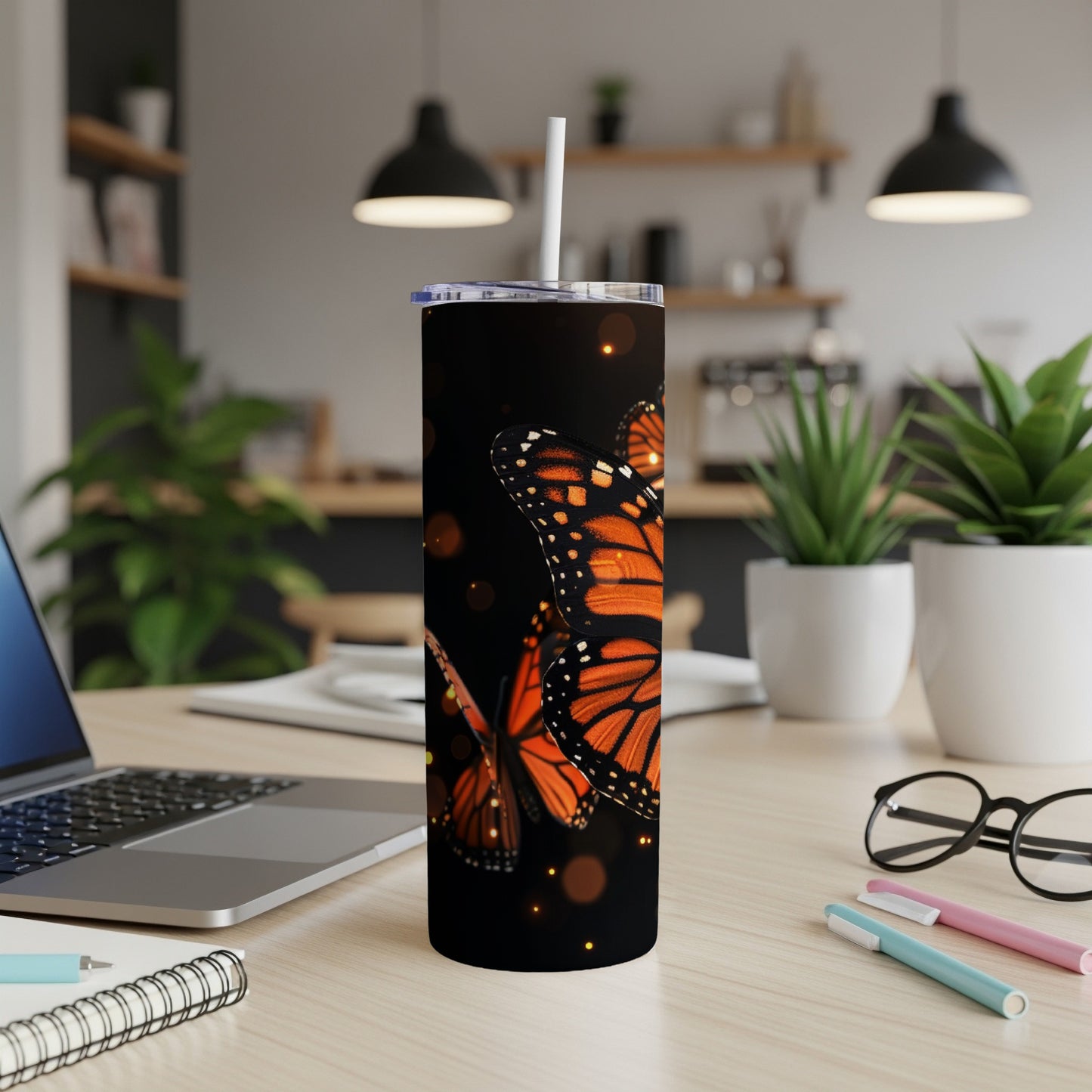 Tall tumbler with monarch butterflies and bokeh lights.
