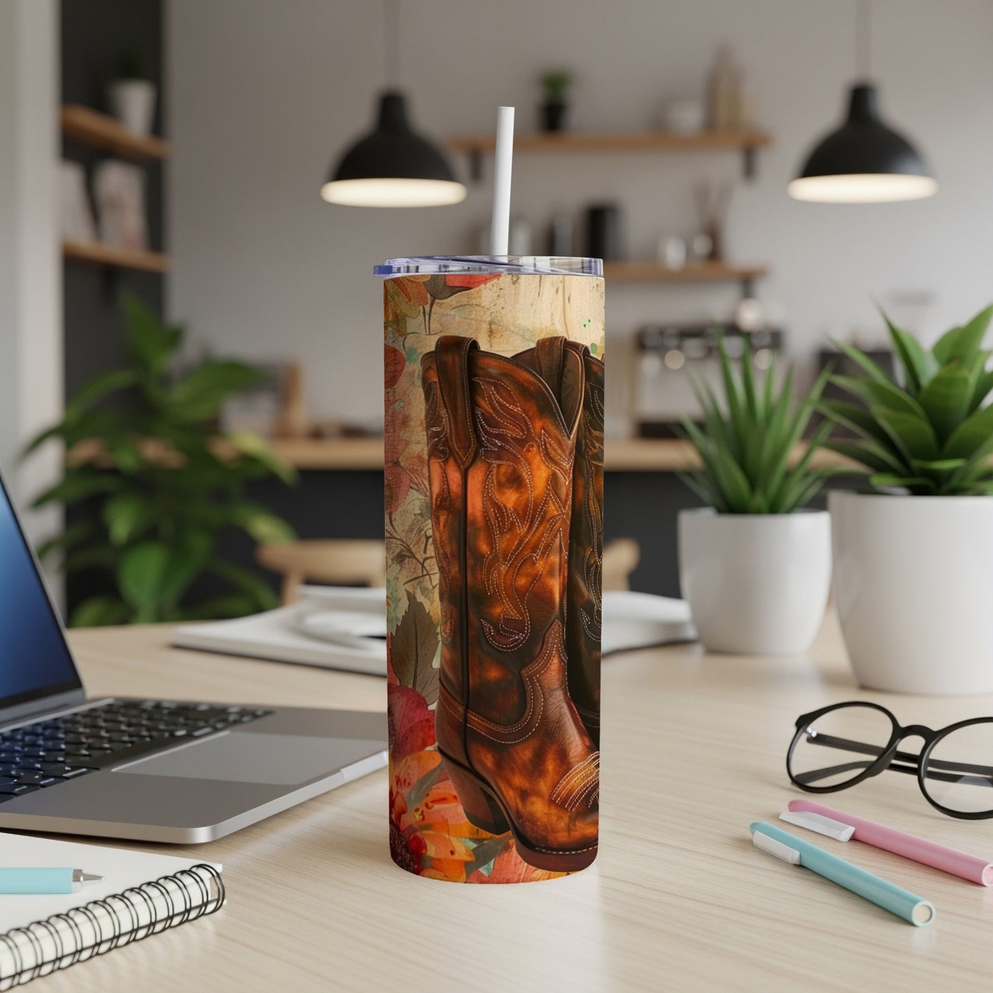 Cowboy boots with autumn leaves design on a tumbler with a straw.