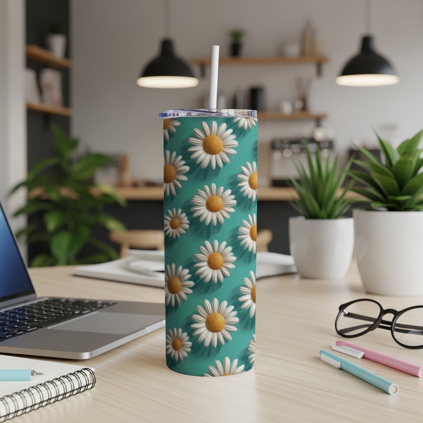 Teal tumbler with repeating white daisy pattern and white straw.