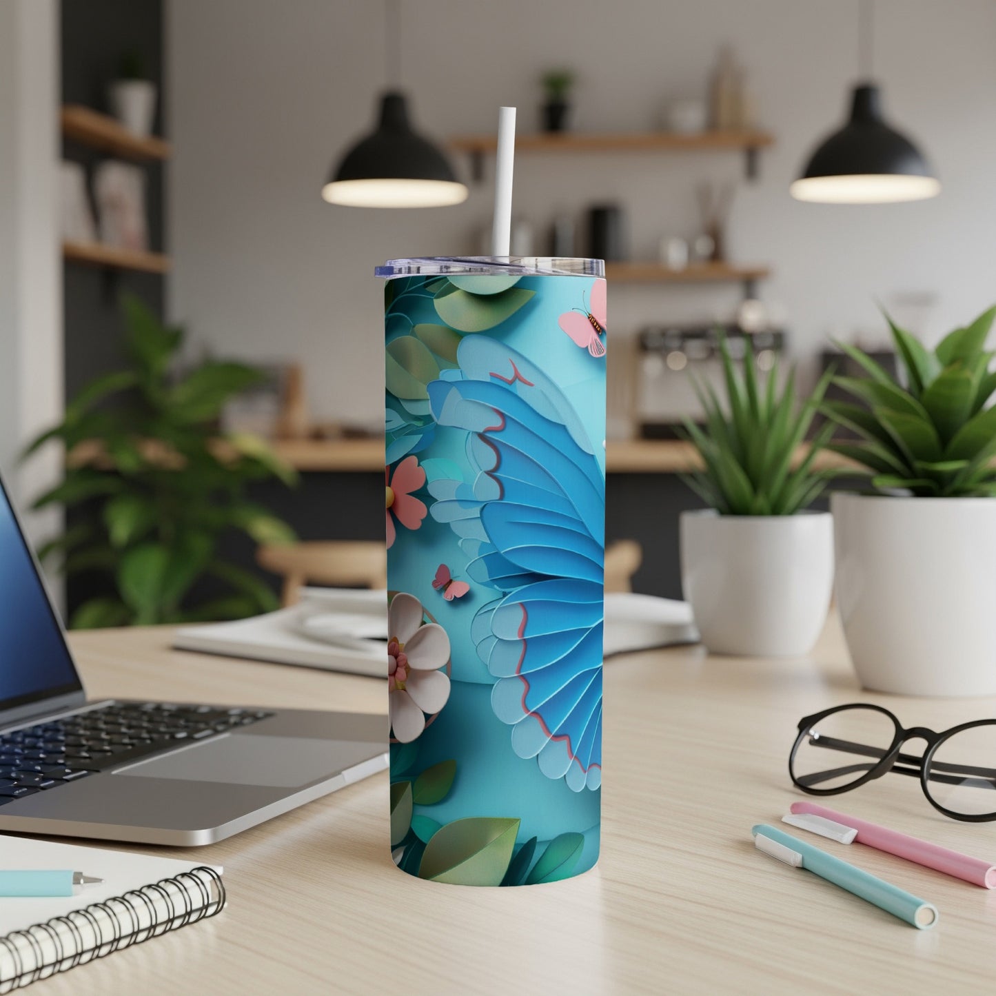 Blue butterfly and floral pattern on a tall, slim tumbler with a straw.
