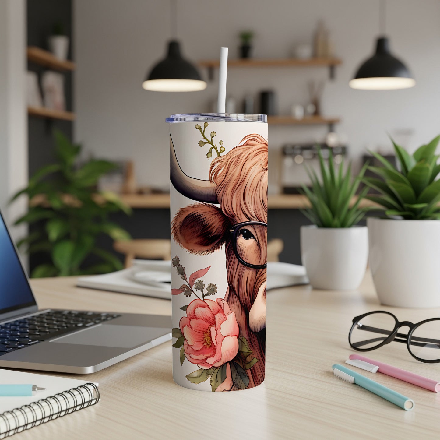 Highland cow illustration with glasses and floral accents on a white tumbler.