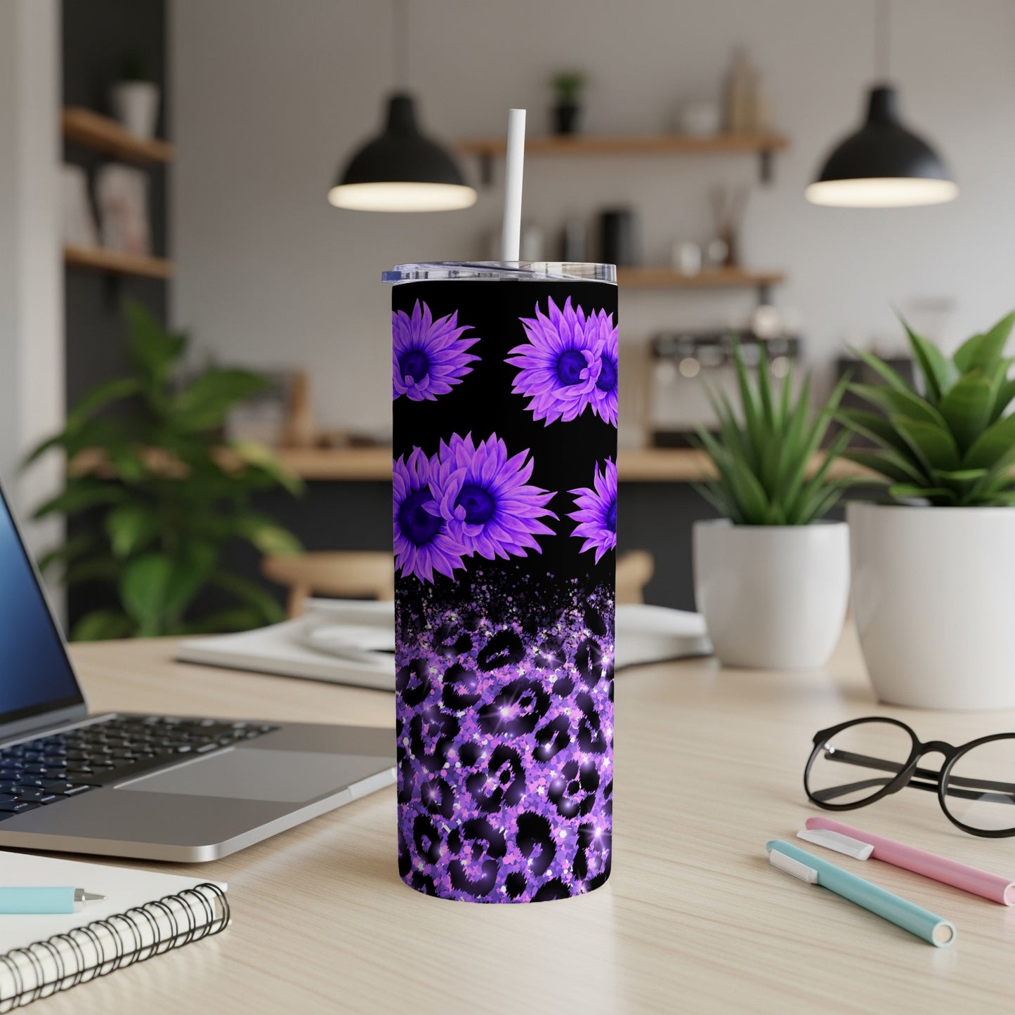 Purple floral and leopard print tumbler with straw on desk.