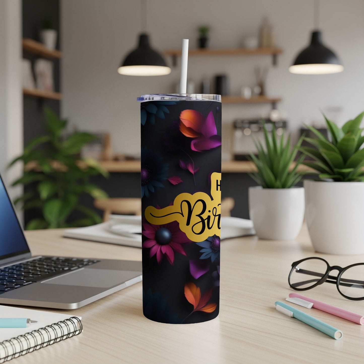 Black tumbler with "Happy Birthday" and floral pattern, straw inserted.