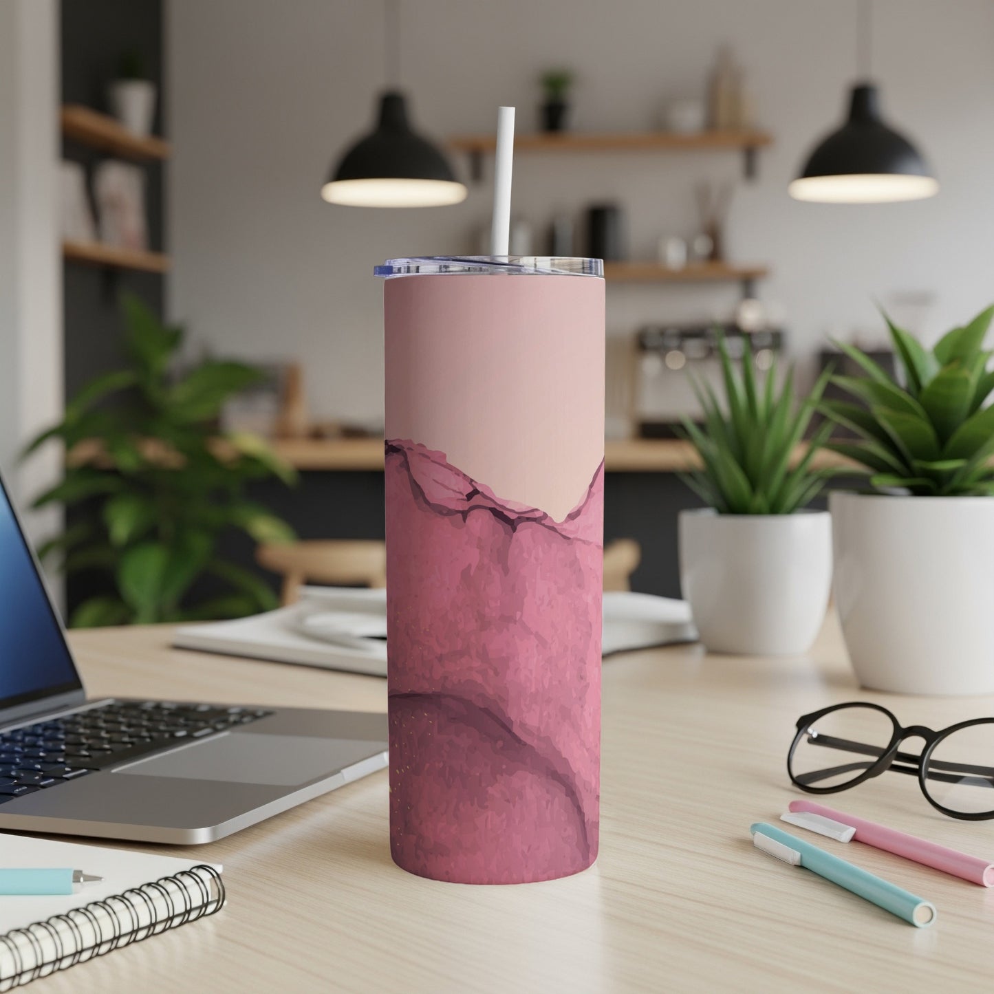 Pink marble pattern tumbler with straw on desk.