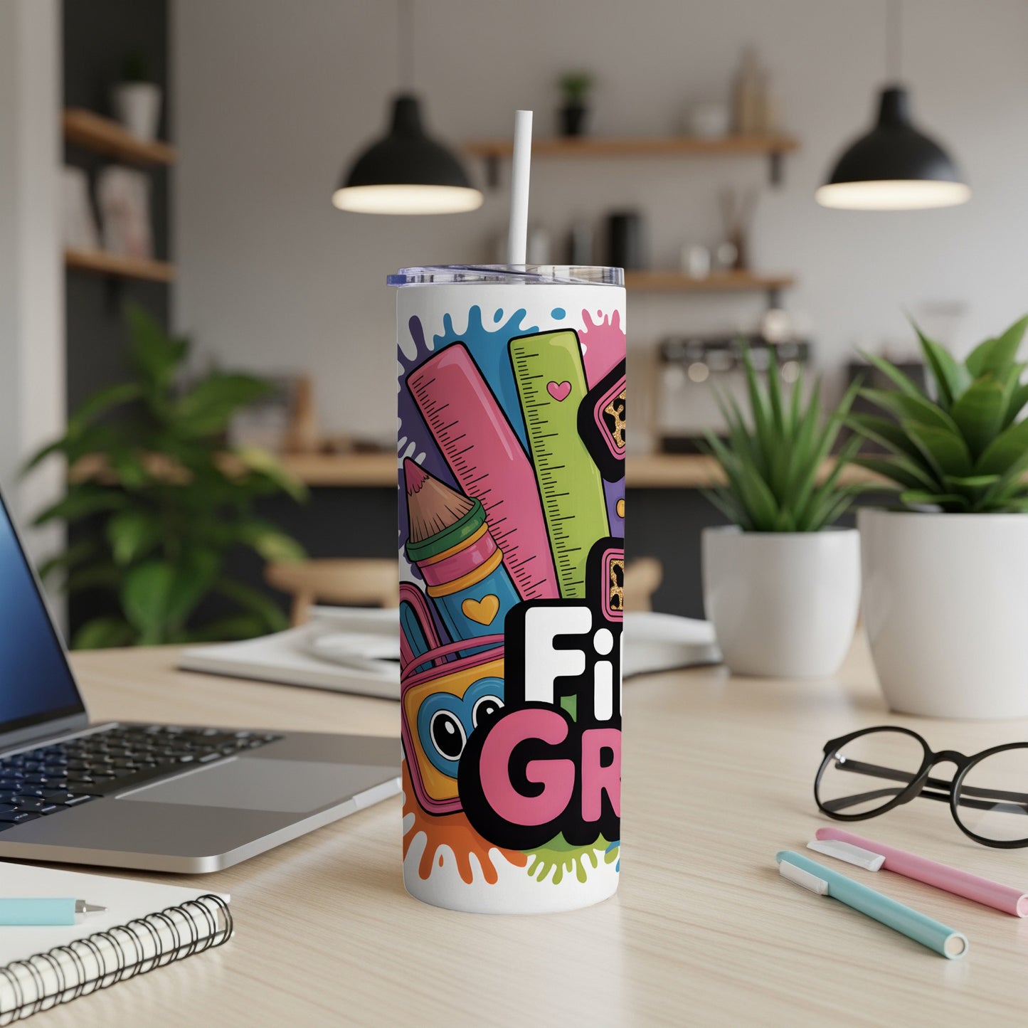 Tumbler with colorful art supplies and the text "First Grade".