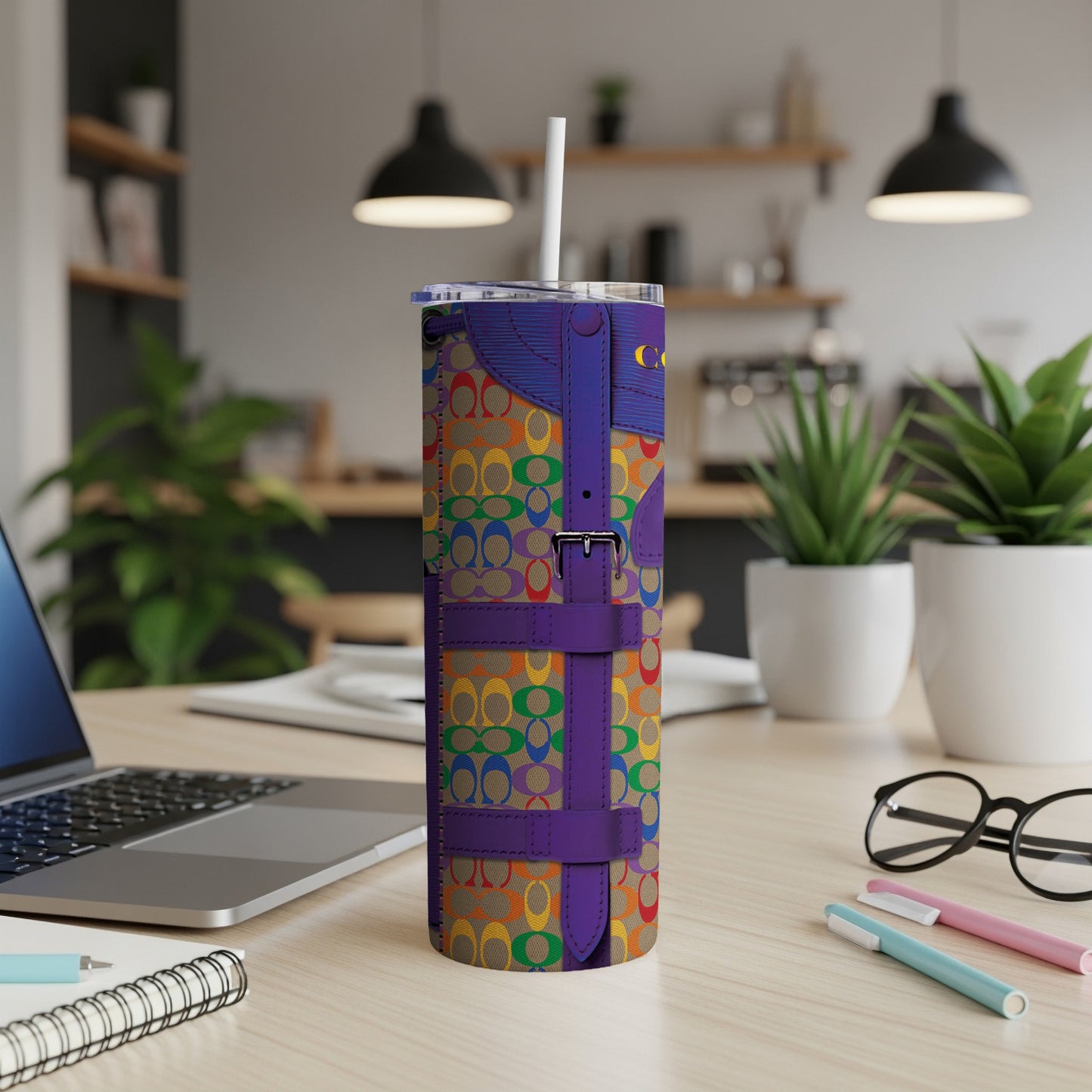 Rainbow patterned tumbler with purple buckle accents and straw.