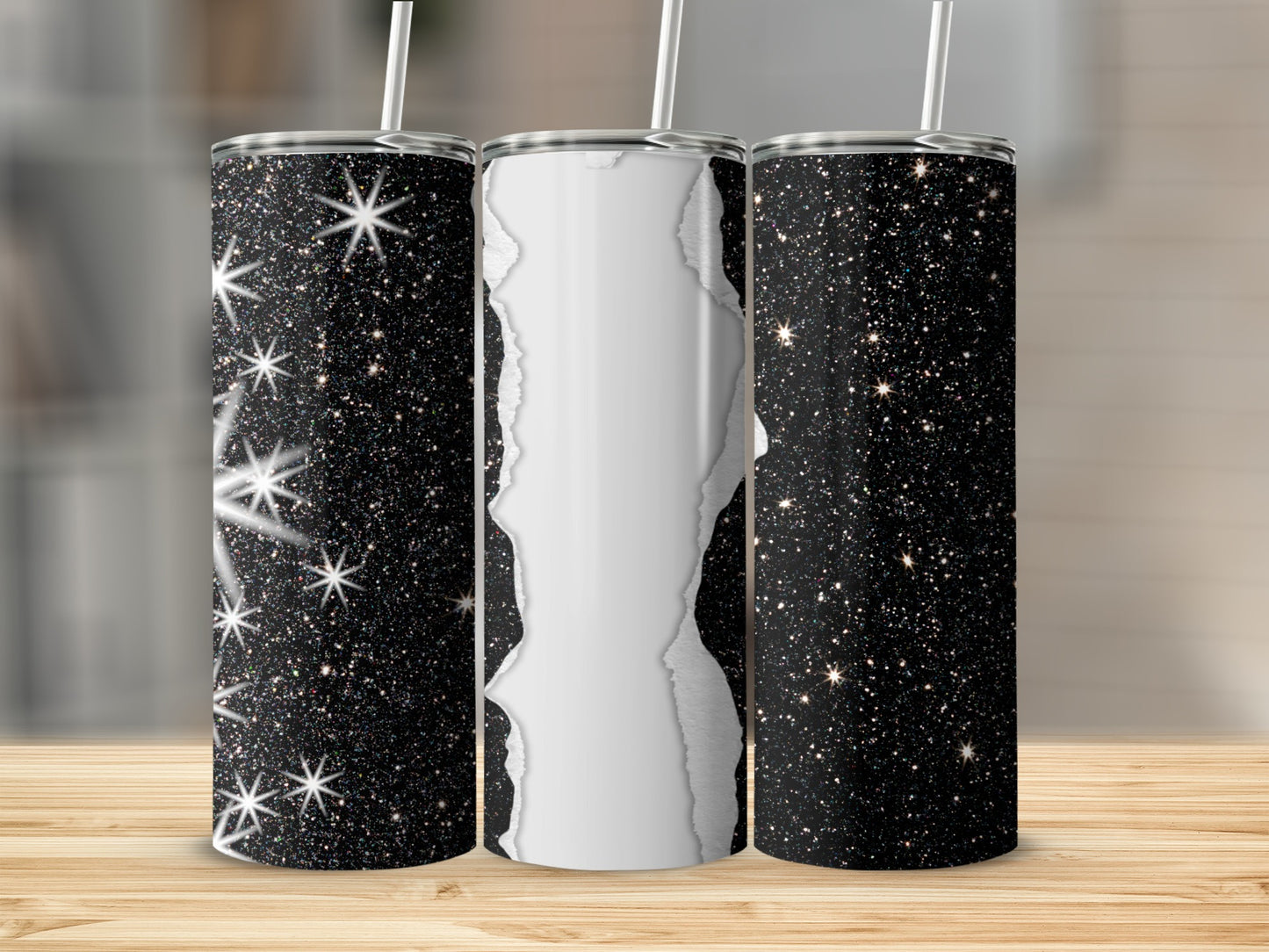Three glittery tumblers with torn paper-like center on wooden surface.